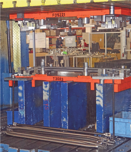 Shown here being stamped on its newly rebuilt 1000-ton mechanical press are truck-hood pivot support bars.